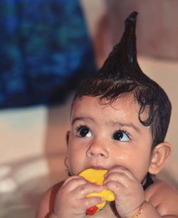 Close-up of cute baby girl chewing rubber duck