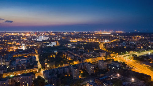 High angle view of illuminated city against sky at dusk