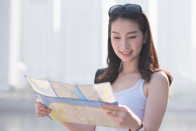 Portrait of smiling young woman holding camera