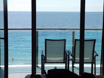 Two empty chairs on seafront balcony