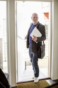 Full length of happy man returning home from office