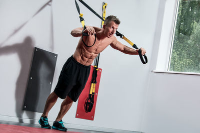 Low angle view of young man exercising at home