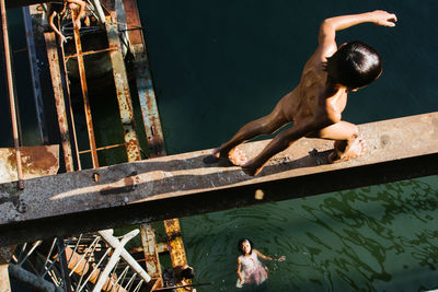 Rear view of shirtless man in water