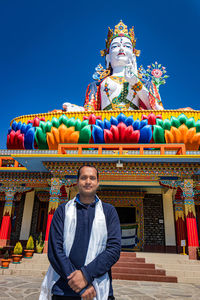 Portrait of man standing against multi colored building