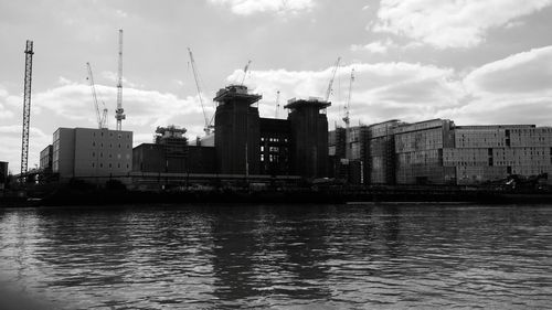 River by buildings against sky