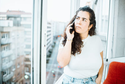 Young woman talking on phone at office