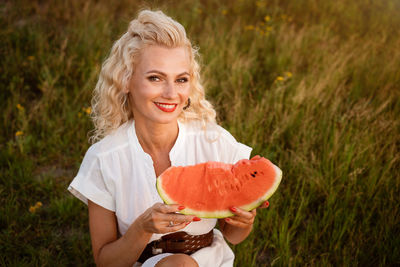 Portrait of a cute woman with a piece of watermelon in her