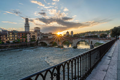 Bridge over river against sky during sunset