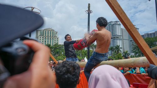 Group of people photographing against sky