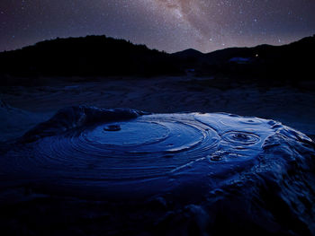 Scenic view of lake against sky at night