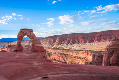 Rock formations on landscape against cloudy sky