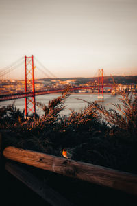 Bridge over river against sky during sunset