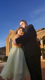 Low angle view of couple standing against built structure