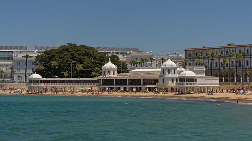 View of swimming pool by building against blue sky