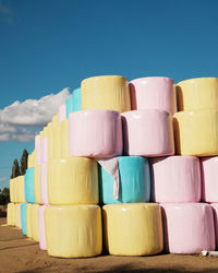 Stack of multi colored pencils on table against blue sky