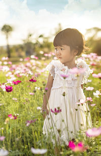 Close-up of girl standing by flowering plants