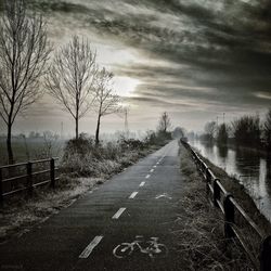 Empty road against cloudy sky