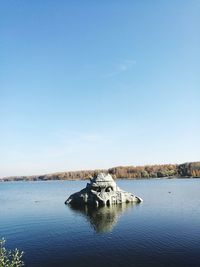 Scenic view of lake against clear blue sky