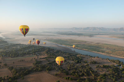 Hot air balloon flying over landscape against sky