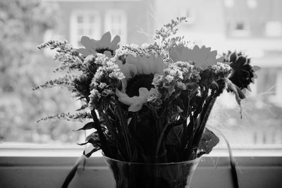 Close-up of flower vase on window sill