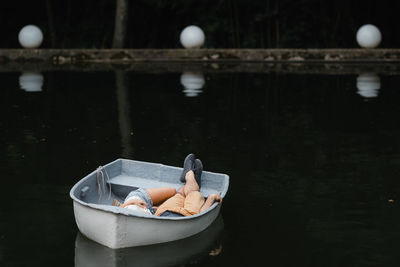 High angle view of couple lying in boat on lake