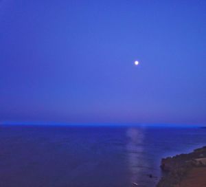 Scenic view of sea against clear sky at night