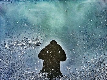Reflection of people in puddle