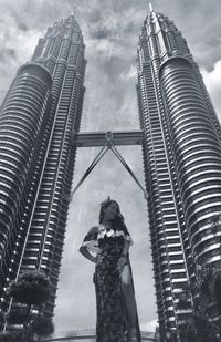Low angle view of woman standing by petronas towers