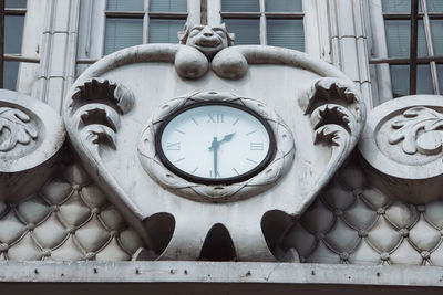 Low angle view of clock on wall of old building