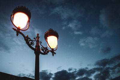 Low angle view of illuminated street light against sky