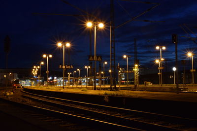 Illuminated railroad station platform at night