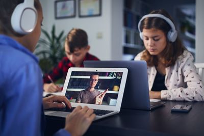 Girls studying at home using digital tablet and laptop