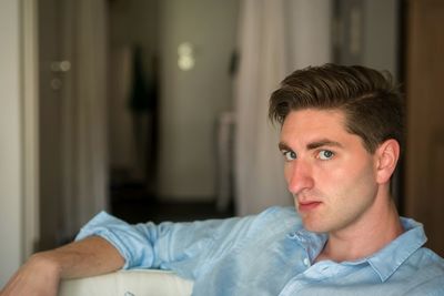 Portrait of young man sitting at home