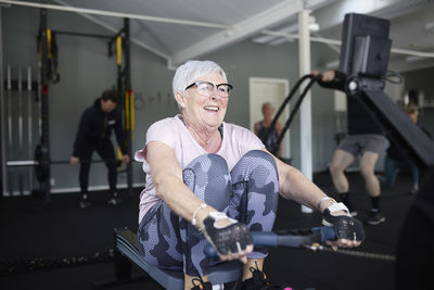 Smiling senior woman exercising in gym