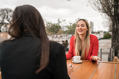 Portrait of smiling woman with coffee at cafe