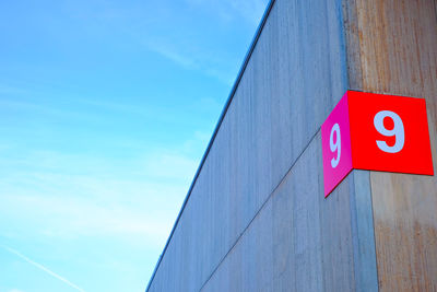 Low angle view of information sign against blue sky