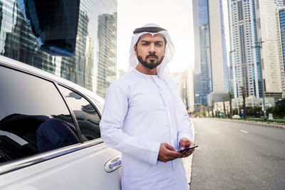 Young man using mobile phone in city