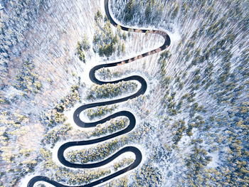 Aerial view of road amidst trees during snowy weather