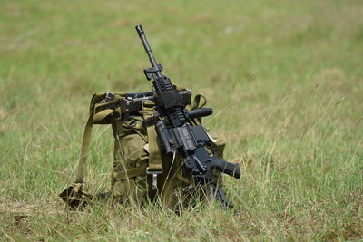 Backpack with gun on grassy field