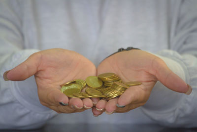 Midsection of person holding coins