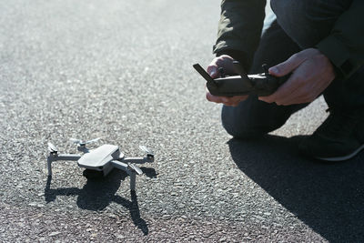 Midsection of man using mobile phone on street