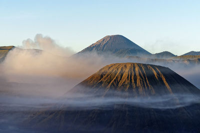 View on a mountain chain surrounded by clouds and fog, morning light, indonesia, java, mt. bromo