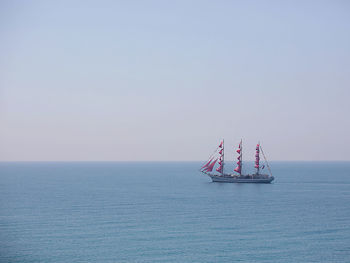 Sailboat sailing in sea against clear sky