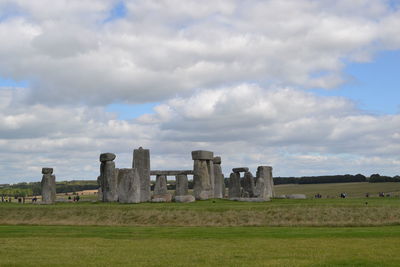 Castle on field against cloudy sky