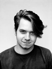 Portrait of smiling young man against white background