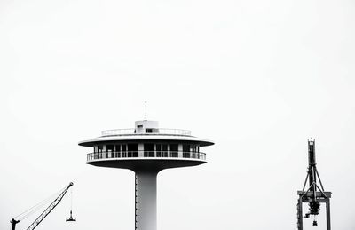 Low angle view of crane and tower against clear sky