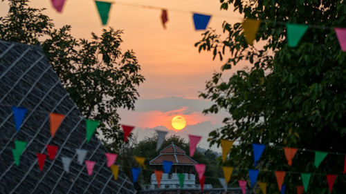 Houses and trees against sky during sunset