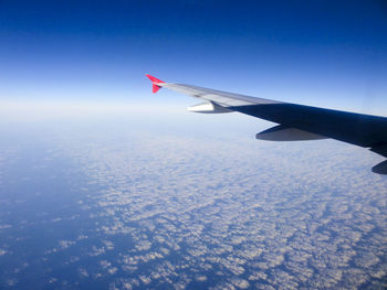 Airplane flying over snow covered landscape