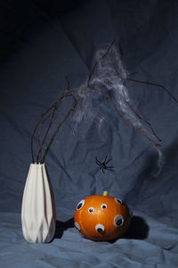 Halloween day composition.party greeting card.pumpkin with eyes and dry branch with spider web