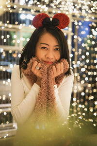 Portrait of young woman blowing bubbles at night